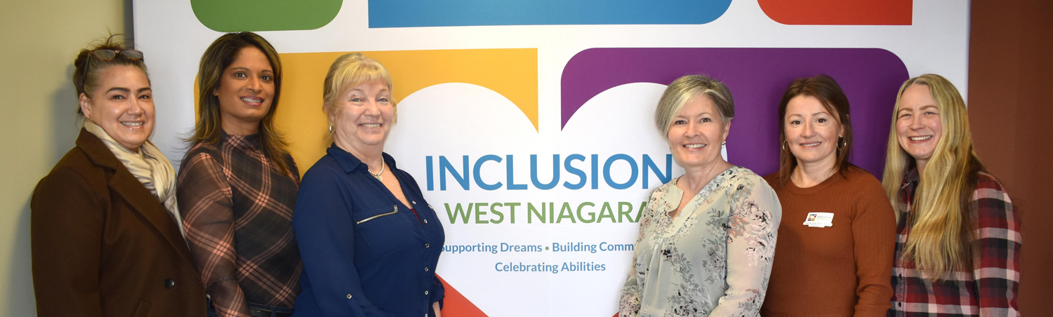 Join Us - executive team standing in front of new logo