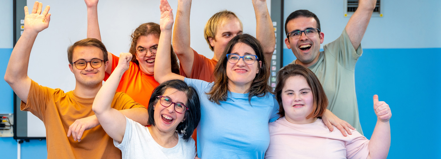 Community Participation Services - group of people smiling at camera with raised arms